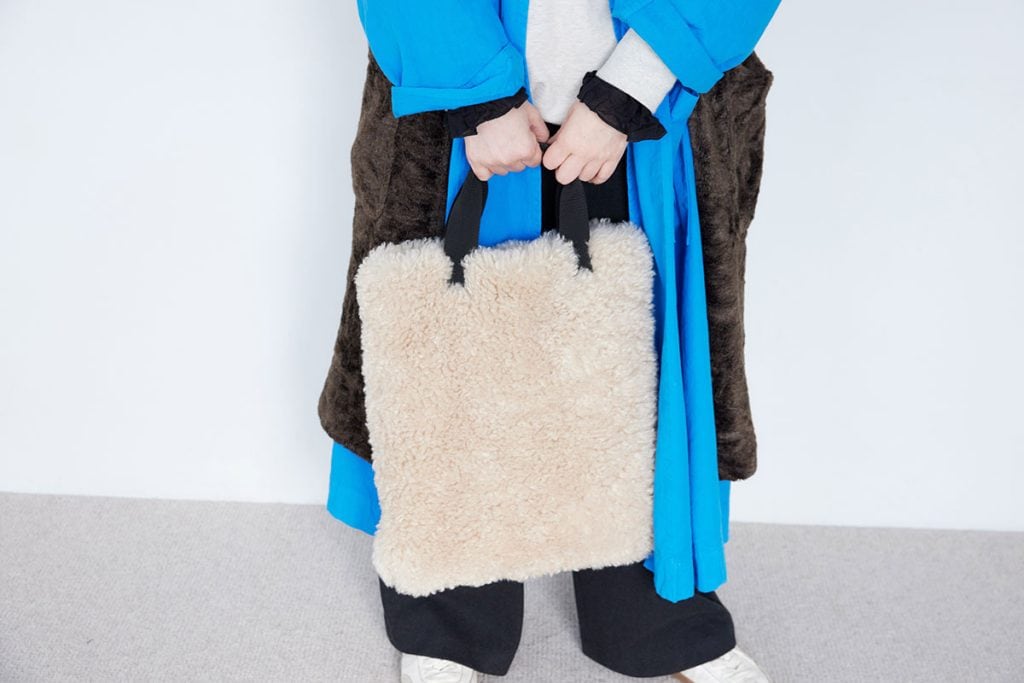 ヘアメイク 高松由佳さんの私服ファッションスナップ。ブルーのコートにブラウンのジレを重ねてメンズライクな冬コーデ