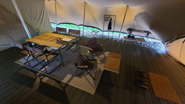 【TENT（テント）】リビングスペース。4人がけのテーブルと、2人用のローテーブル。奥には洋服かけやキッチンテーブルがあります。