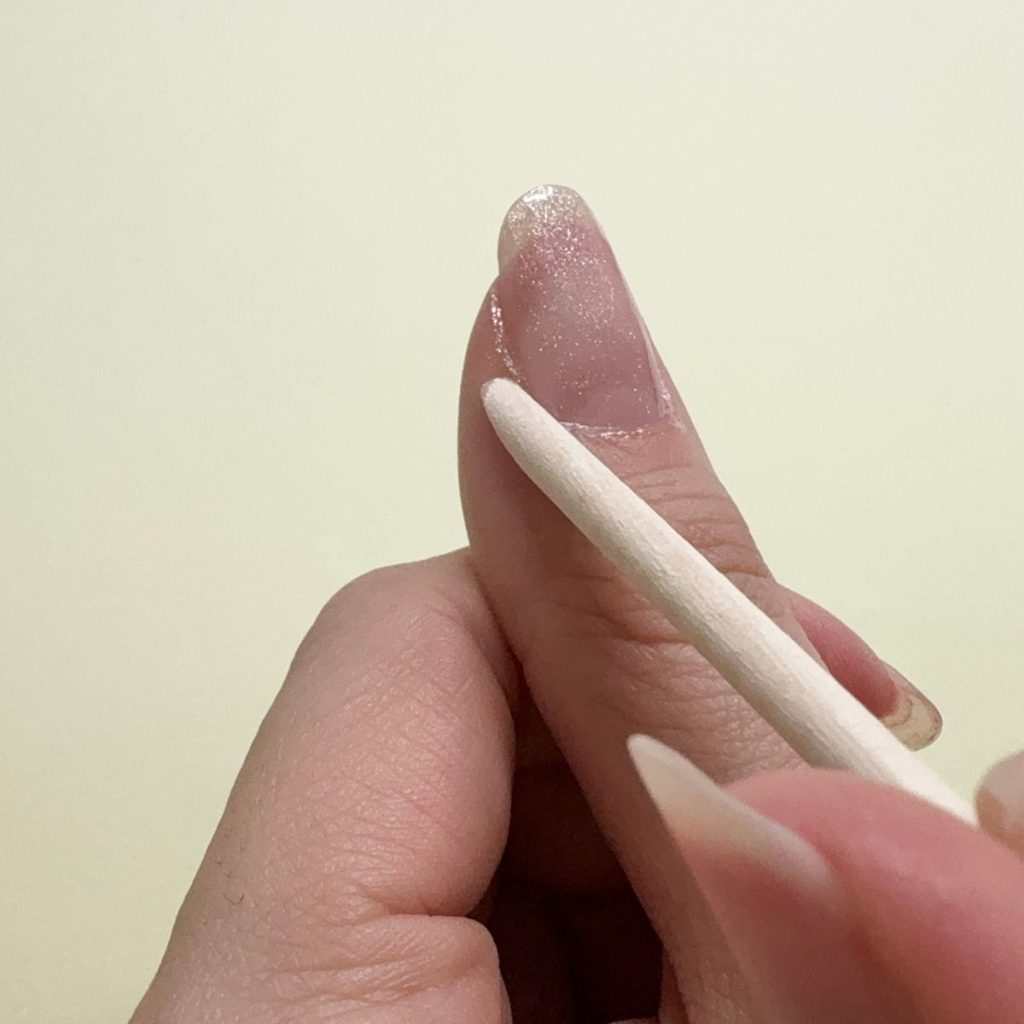 ジェルがはみ出た部分は、ウッドネイルスティックを使って整えます。爪に残ったまま硬化すると皮膚を傷めるのでご注意ください。