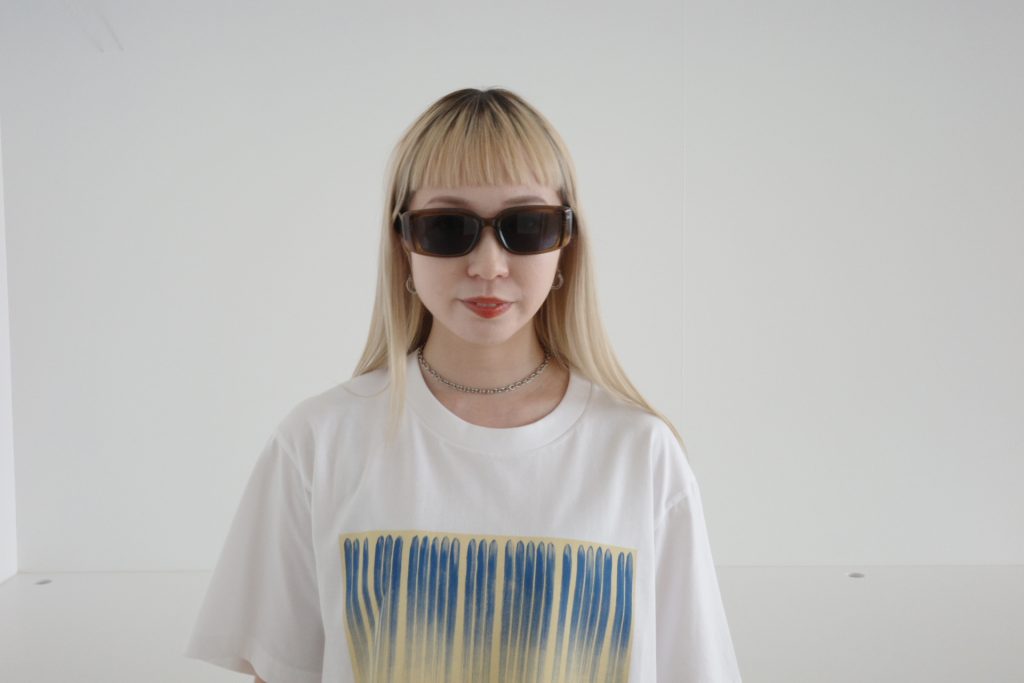 30代のハイトーンヘアの女性に似合うユニクロのサングラス。未来的なレクタングルフレームで刺激をプラス！