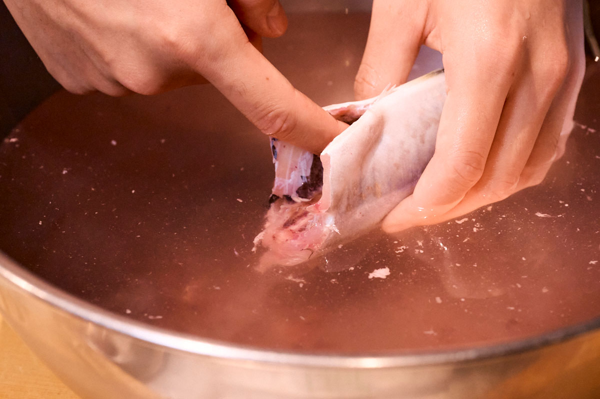 ボウルにためた冷水で腹の血合いや汚れを洗い流します。残っているとくさみの原因になるのできれいに洗って。