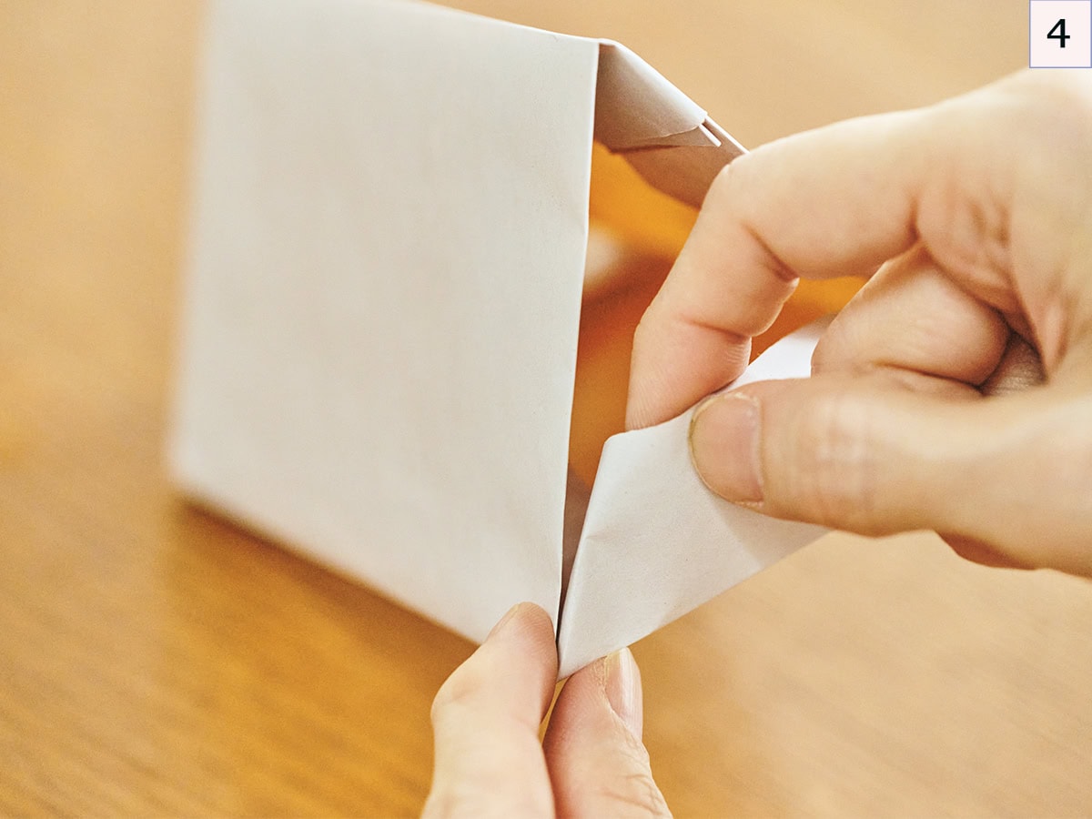 脇の3cm部分を、三角形の辺に沿わせるように折り整えれば、できあがり。【かわいいおうちボックスの作り方】