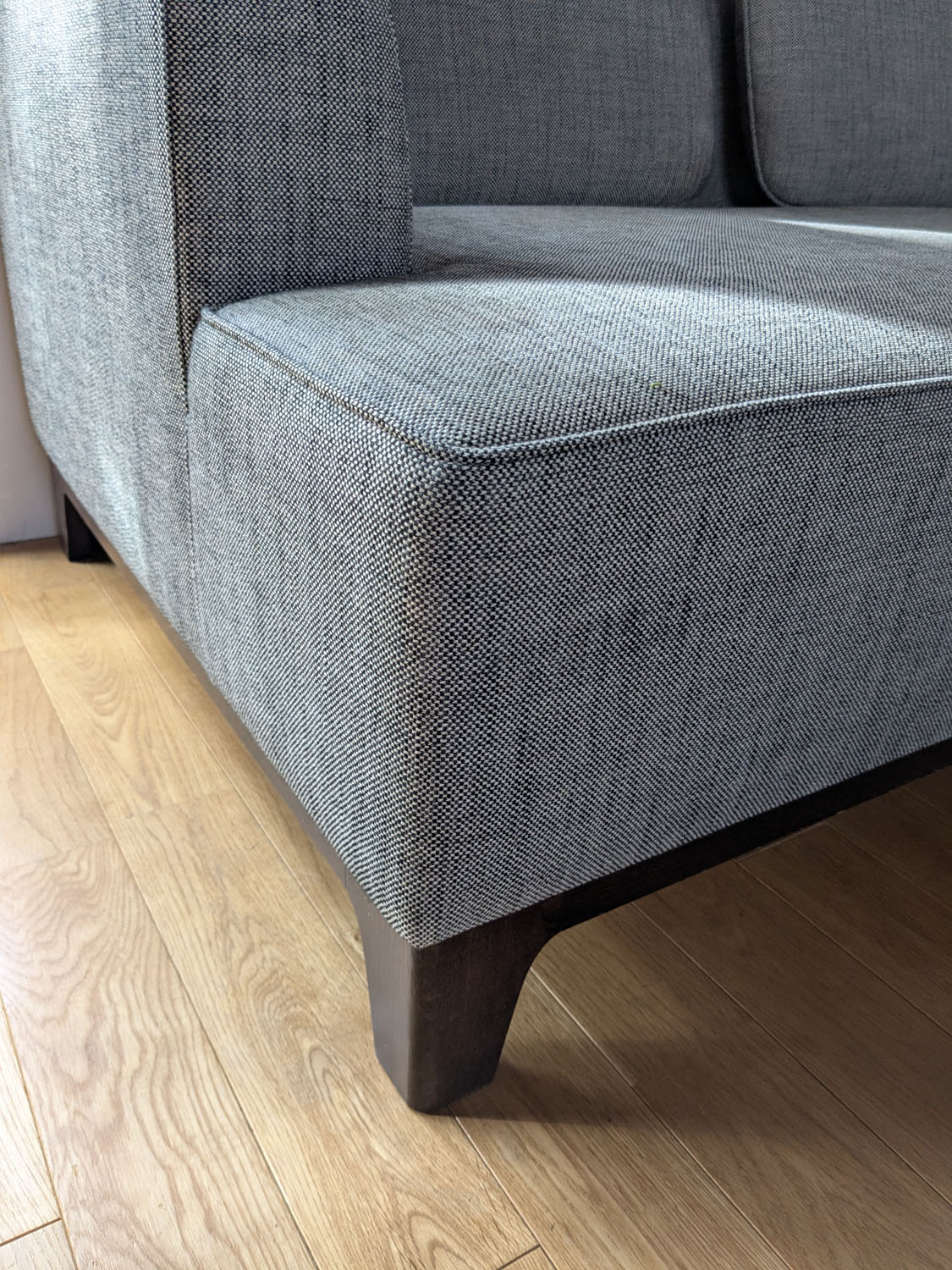 IDEEのAGLAS SOFAの生地は、綿麻で肌触りがよくデニムの様にタフなものを選び、脚の染色はマジメな佇まいを活かせるようダークブラウンを選んで、渋めの配色のソファに仕上がりました。