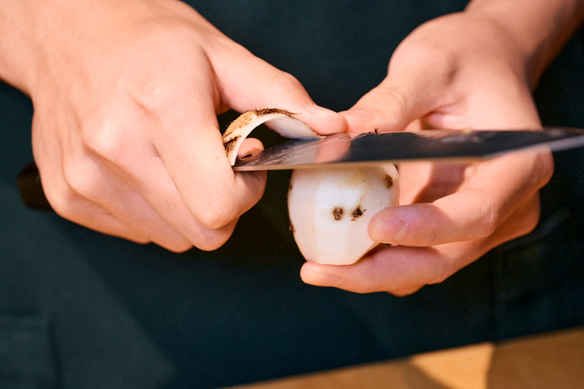 里芋の皮むきをする手元