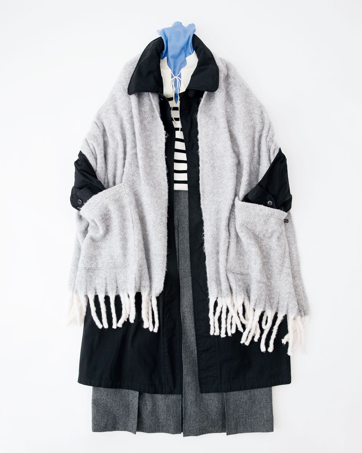 ほどよくハリのある生地を使用したきちんと感のあるコートは、ふんわりとしたボリュームのある大判ストールをまとってやわらかさをプラス。