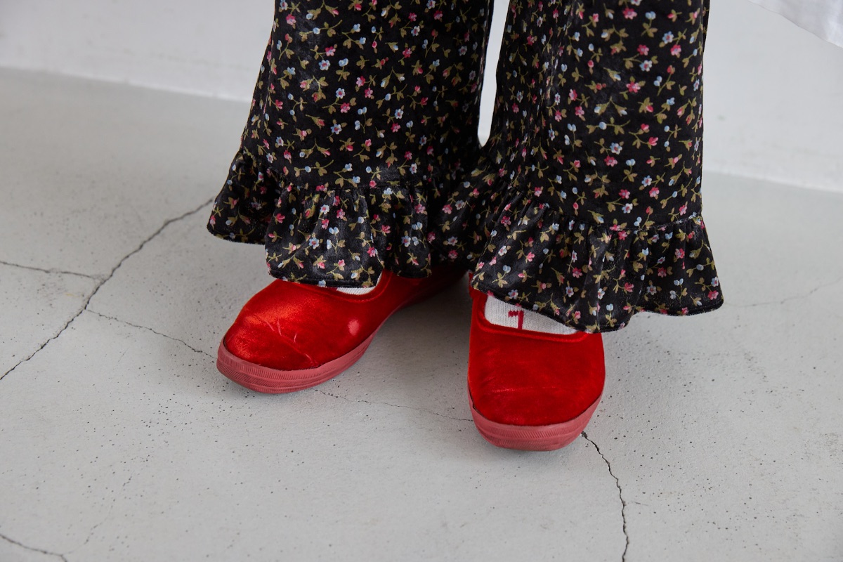 小花柄のフリルパンツに合わせた、ケッズ × ビュルデサボンの赤ベロアのストラップシューズ