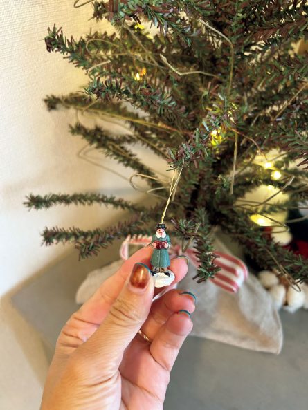 クリスマスマーケットで見つけたオーナメントをツリーに飾っている