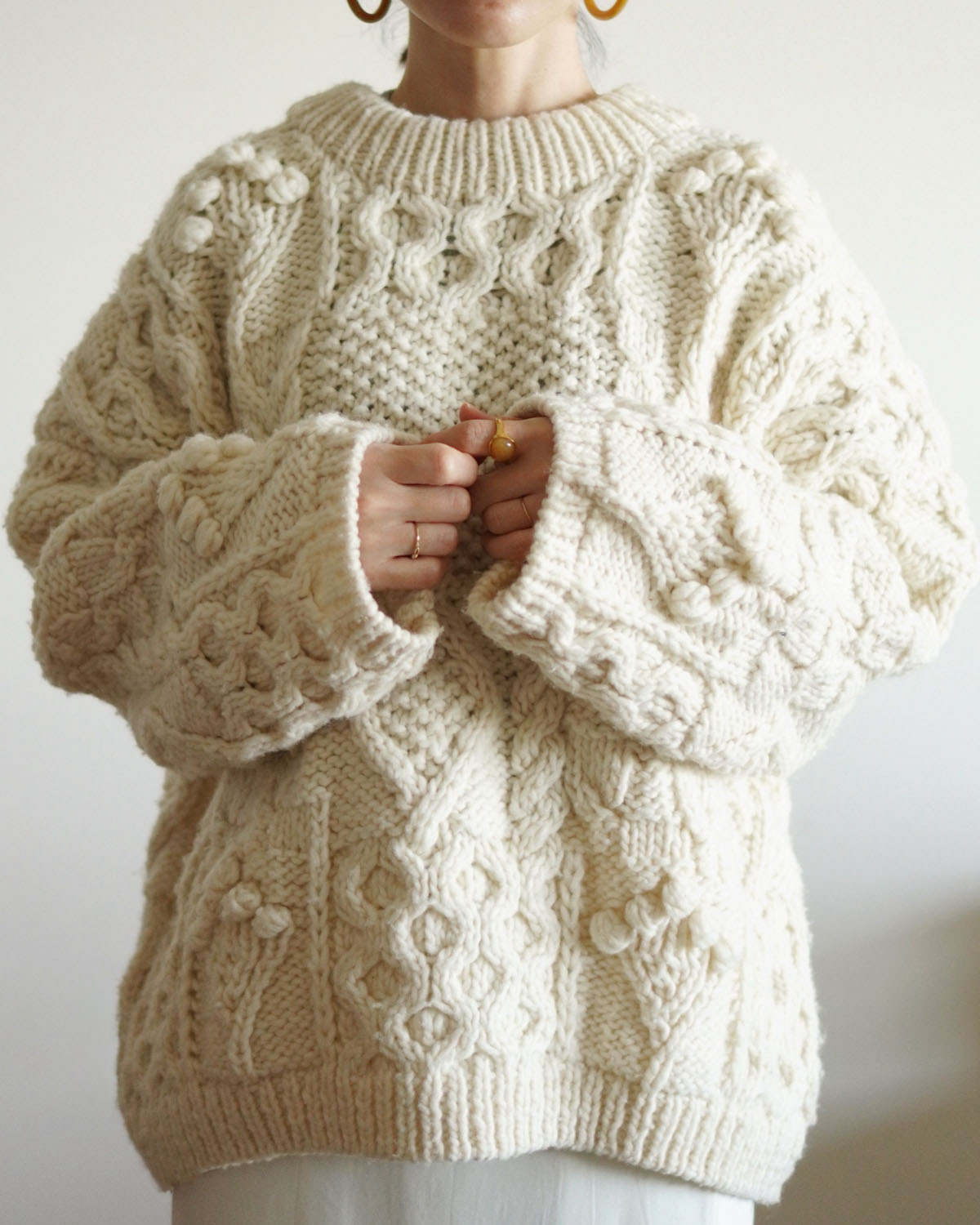 ペルーでひとつひとつ手編みで作られたハンドニットは、温かみを感じる1枚。