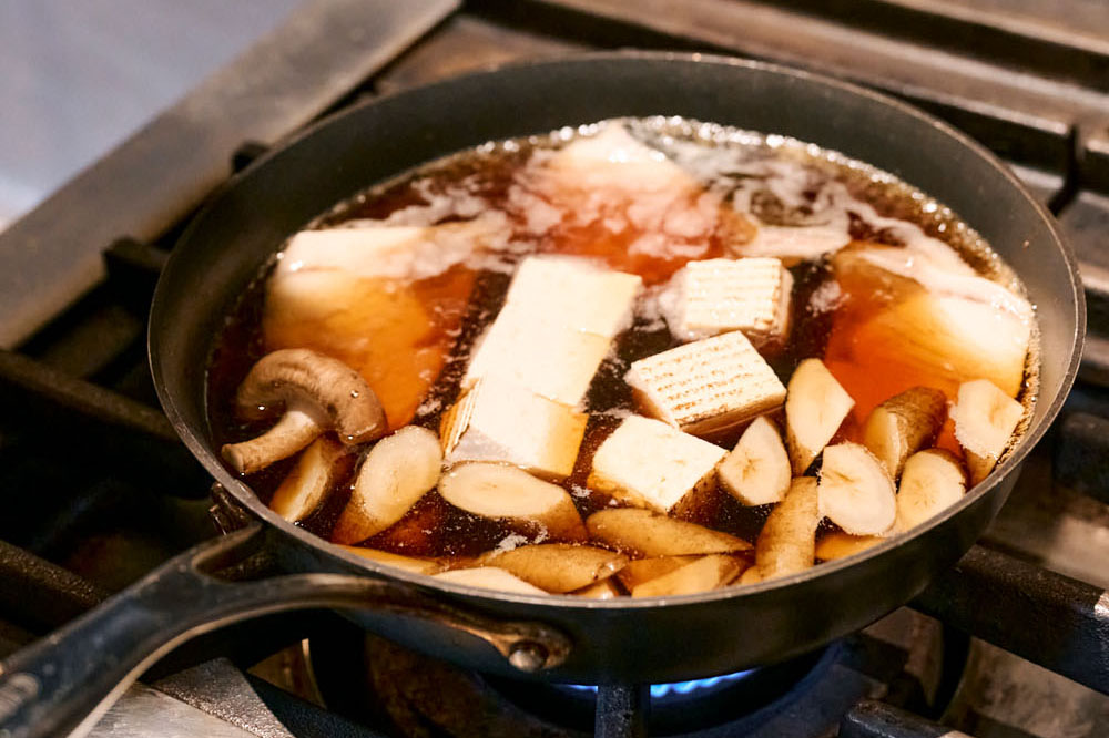 フライパンでぶりとごぼう、豆腐を煮る