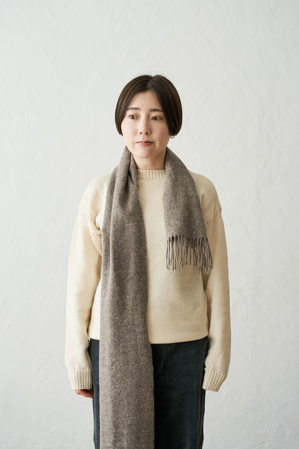 片方のマフラーが短くなるよう首に巻く