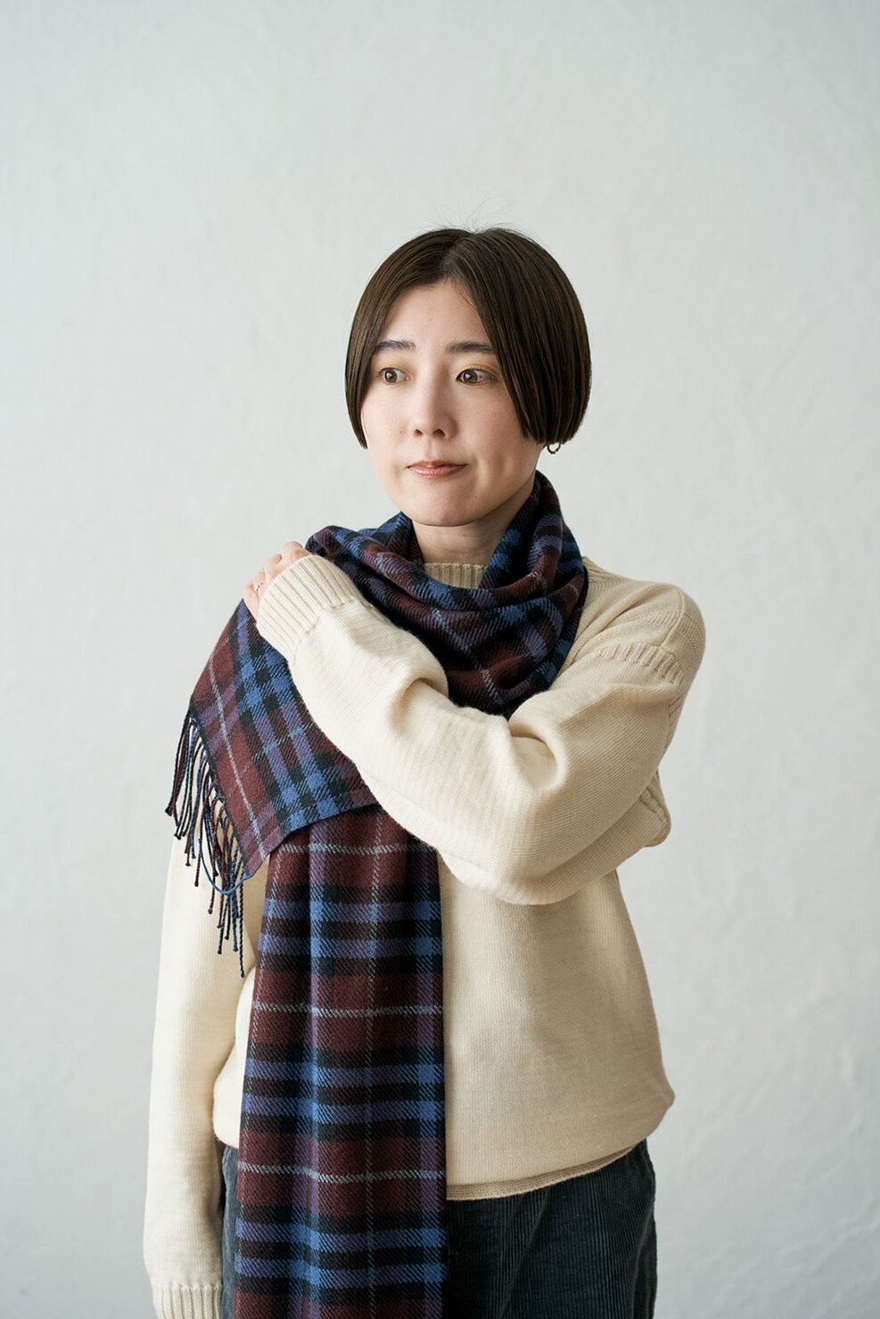 短い方の裾を反対の肩に乗せ、そのまま手で押さえておく