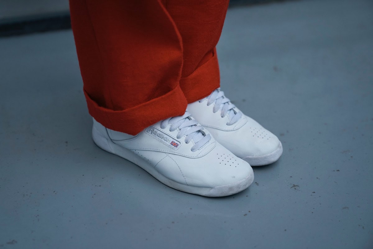 赤いパンツに合わせた、冬の着こなしを軽やかに仕上げる、リーボックの白スニーカー
