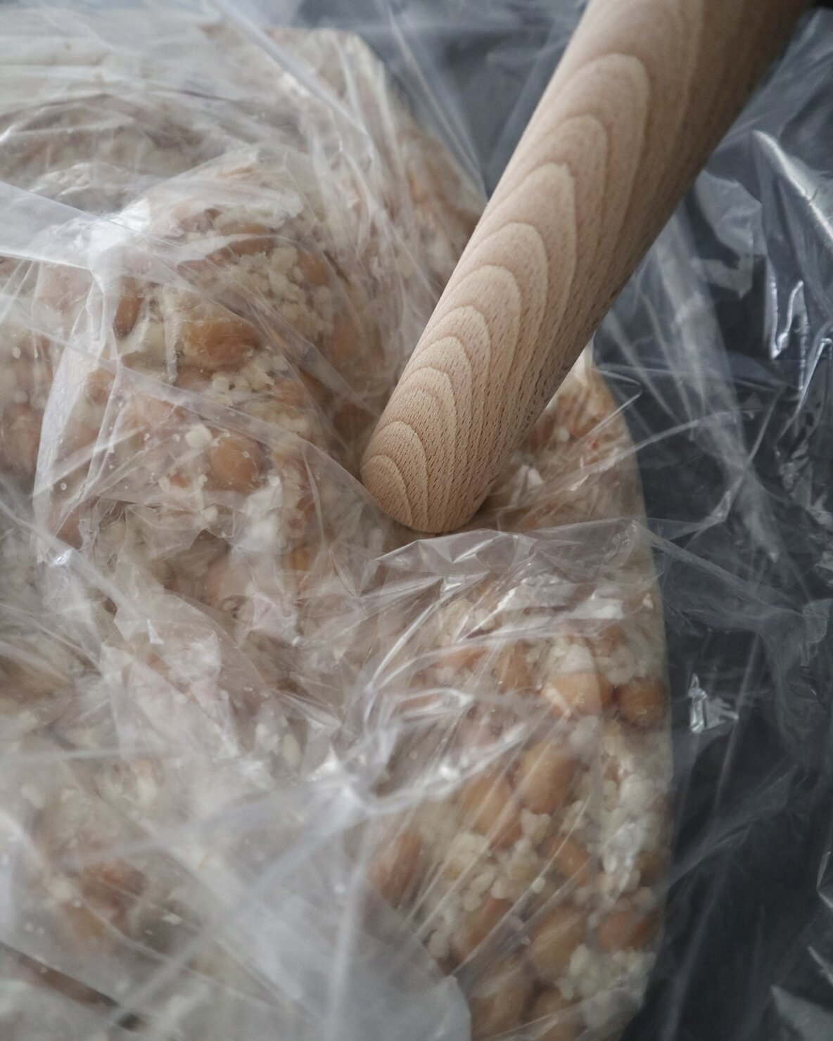 味噌づくりで綿棒で大豆を潰しているところ