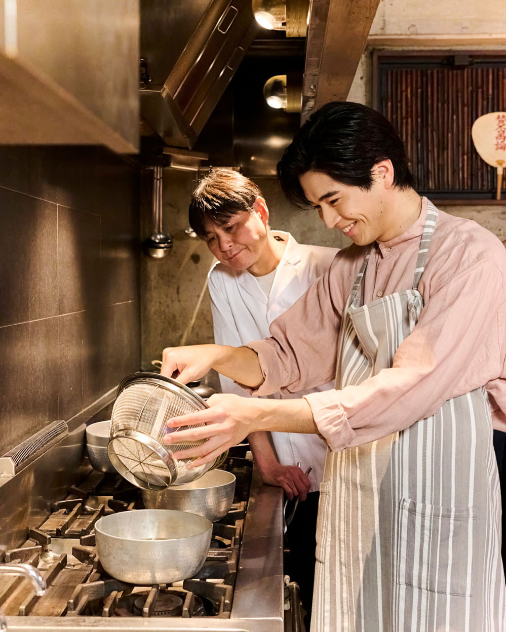 笠原さんの1.5番出汁をざるで絞り出す中沢元紀くん