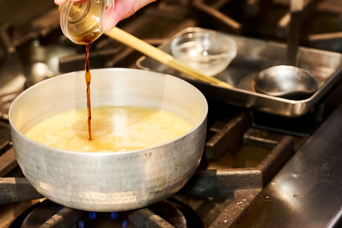 みそ汁にしょうゆを入れているところ