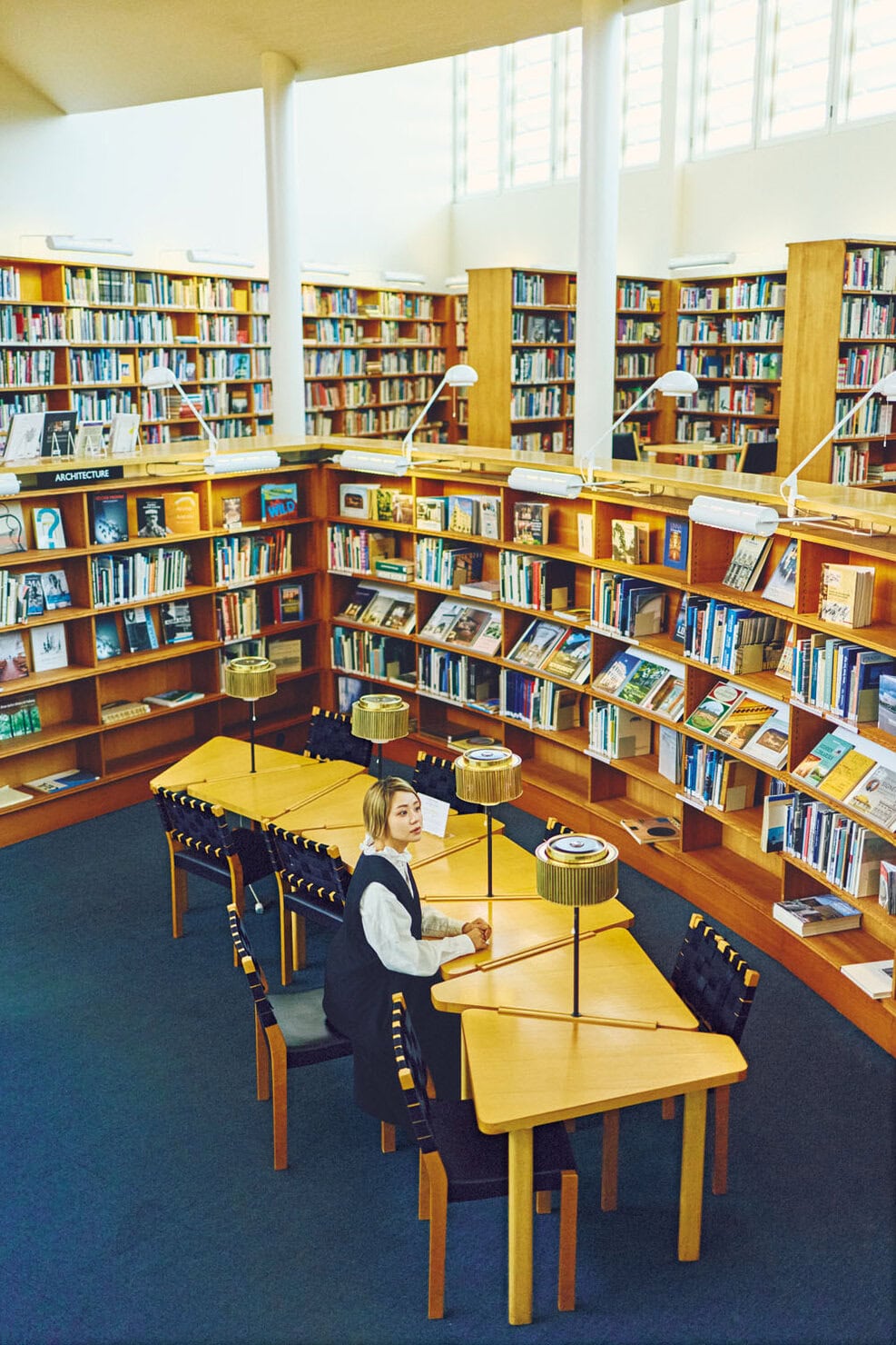 アアルトデザインの机や本棚、照明に囲まれた図書館。