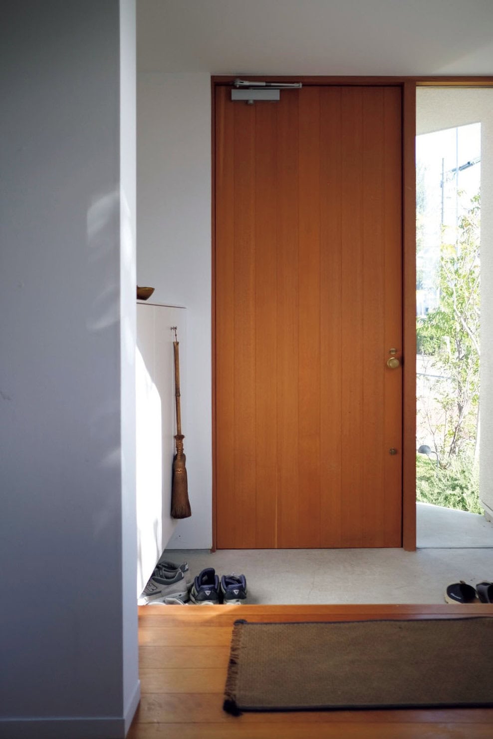 扉は造作で、真鍮のドアノブがどんどん味が出ていい雰囲気に。 シューズクローゼットの上には絵を飾ったり、季 節のアイテムを置いたりして楽しんでいます。