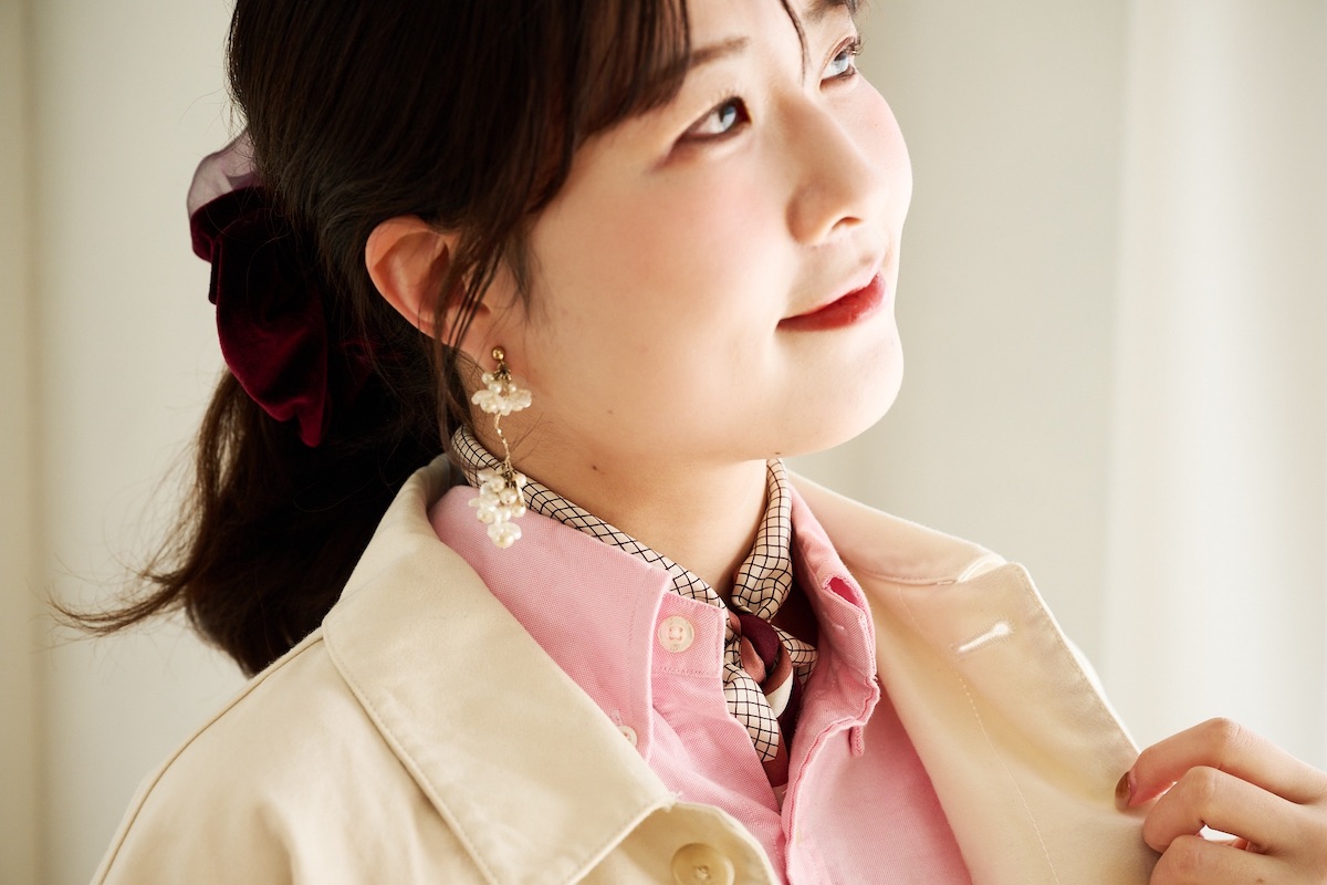 ピンクシャツに合わせたUNFOLKのシルクスカーフを首元に巻いたコーディネート