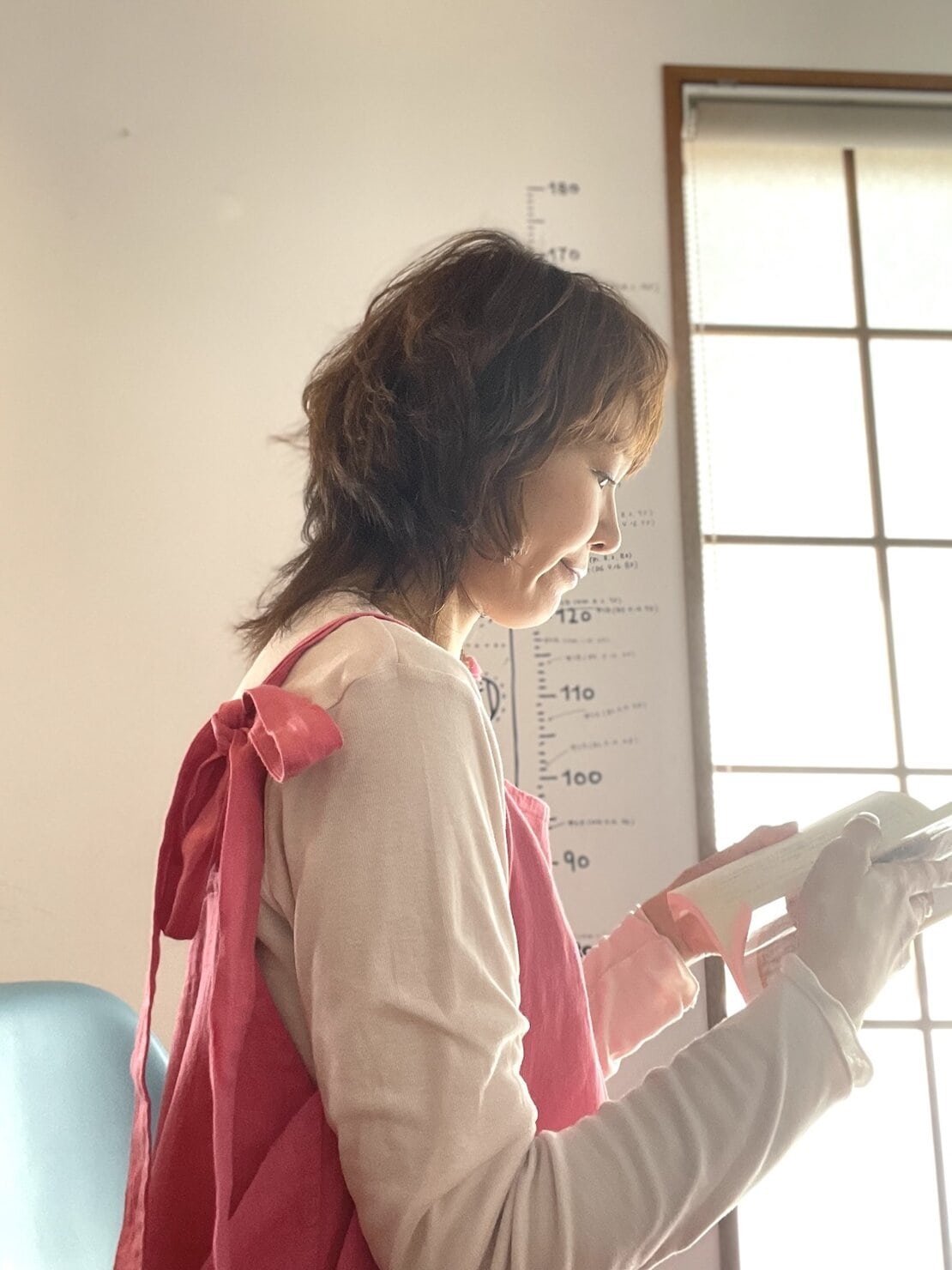 受注会で届いたピンクのサロペットを着て本を読んでいる