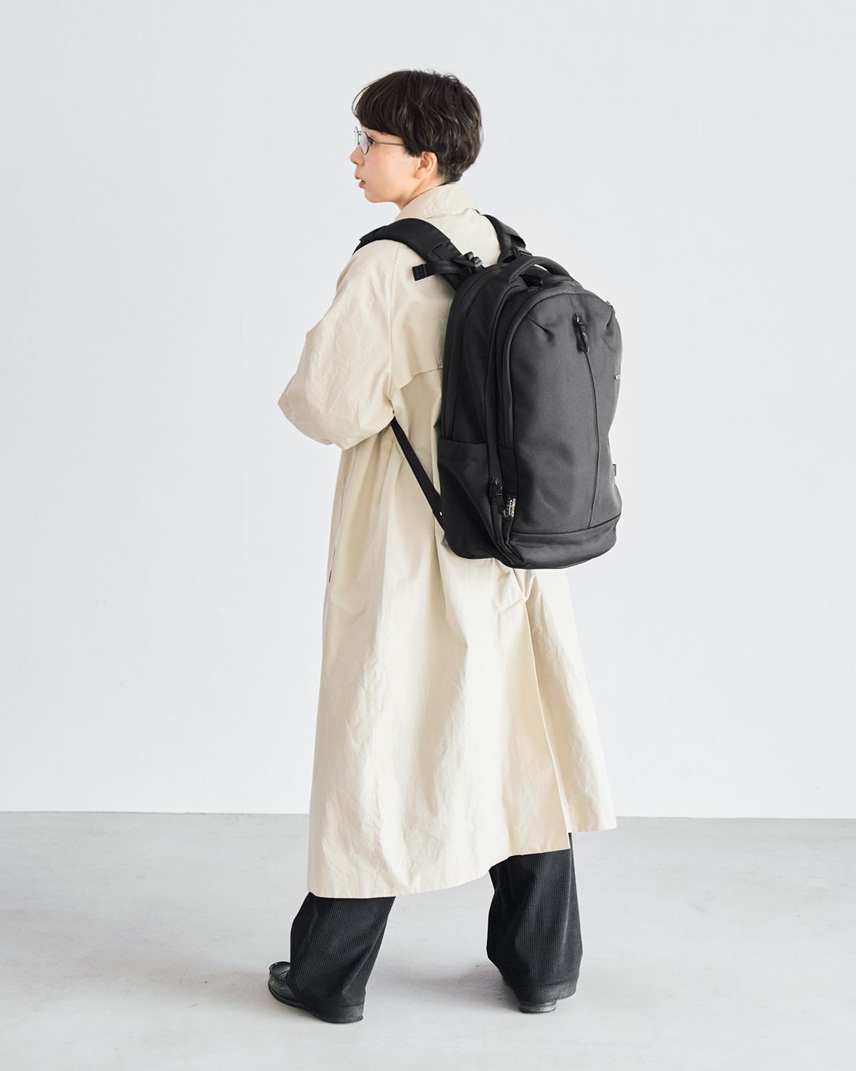 ロング丈のアウターで縦のラインを意識して、リュックの立体感を自然になじませたコーディネート
