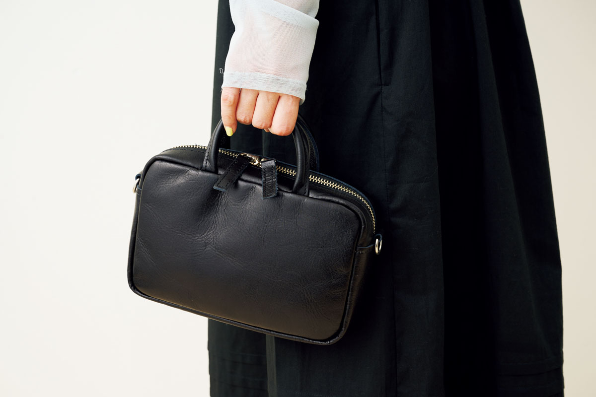 小ぶりなレザーバッグで、装いを上品に引き締めて。