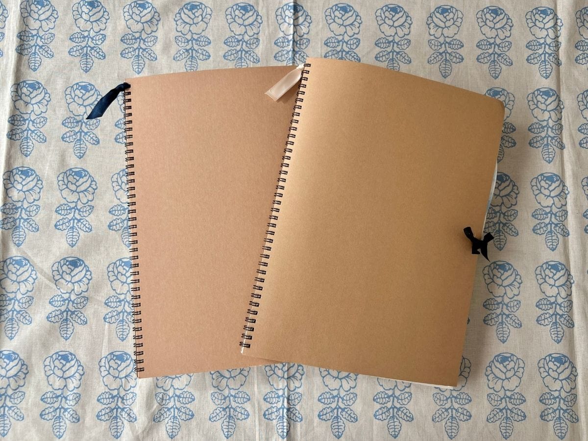無印良品のスケッチブックをマリメッコの布の上に広げて