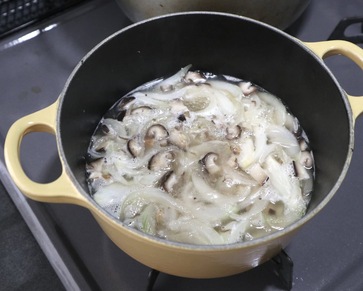 ポタージュづくりで新玉ねぎとしいたけを入れた鍋に水を入れて煮ているところ