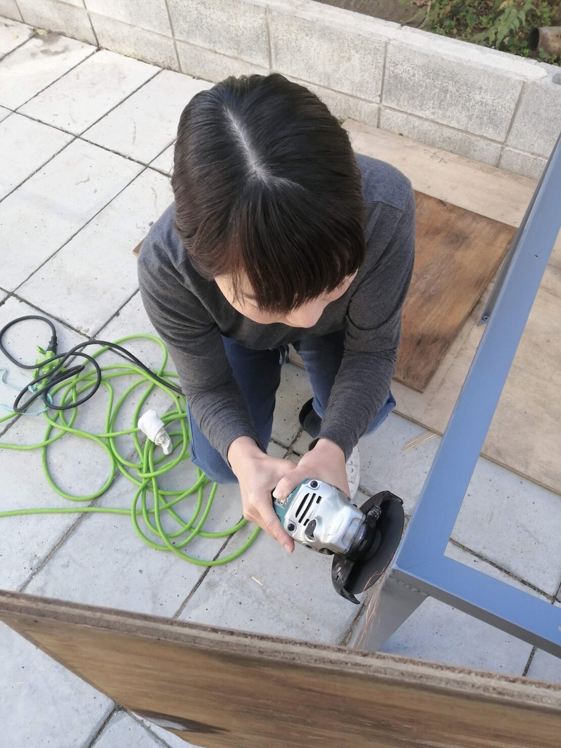 ハーフメイドテーブルの脚の溶接部分を電気サンダーで平らにする