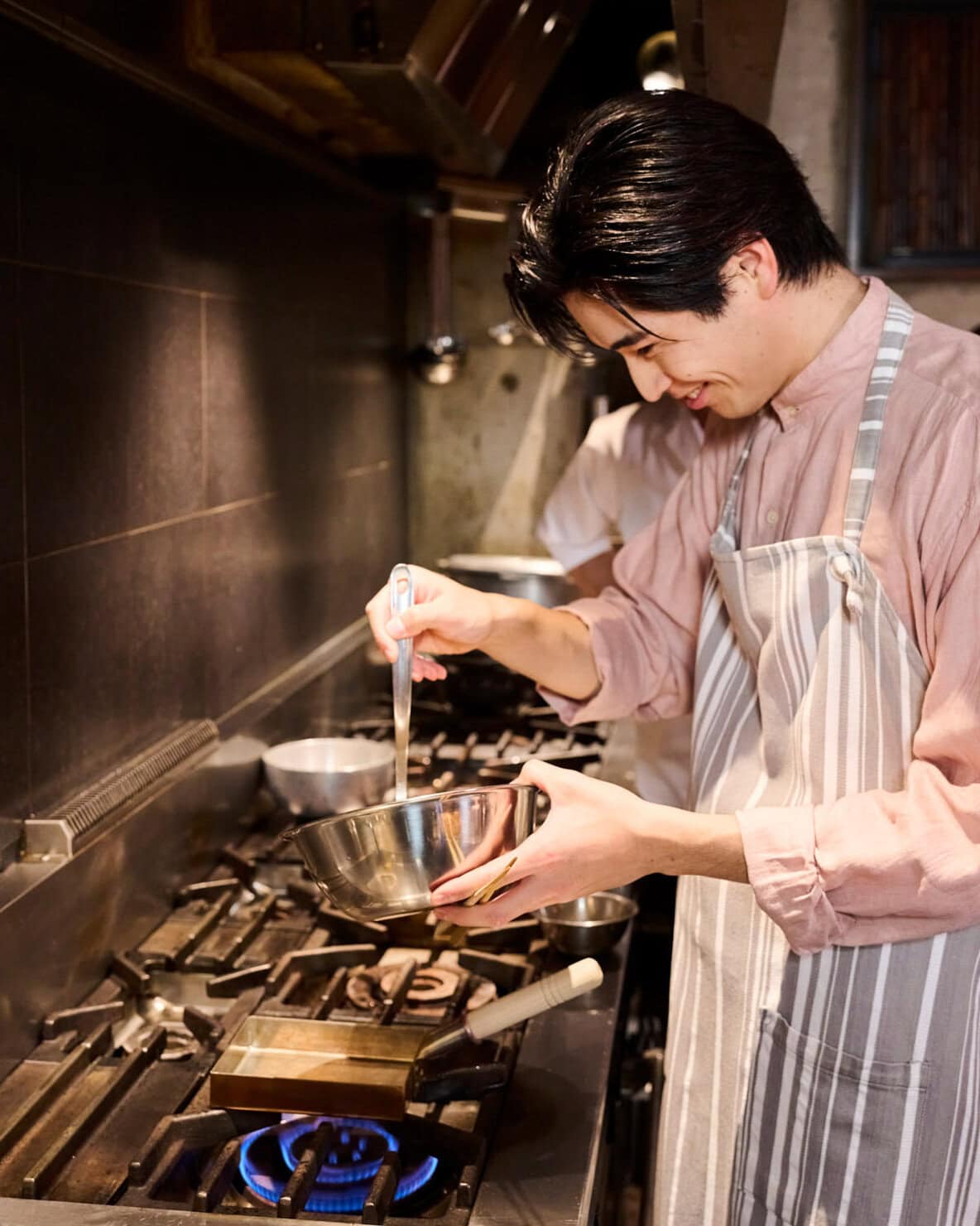 卵焼き器に卵液を流す中沢元紀くん