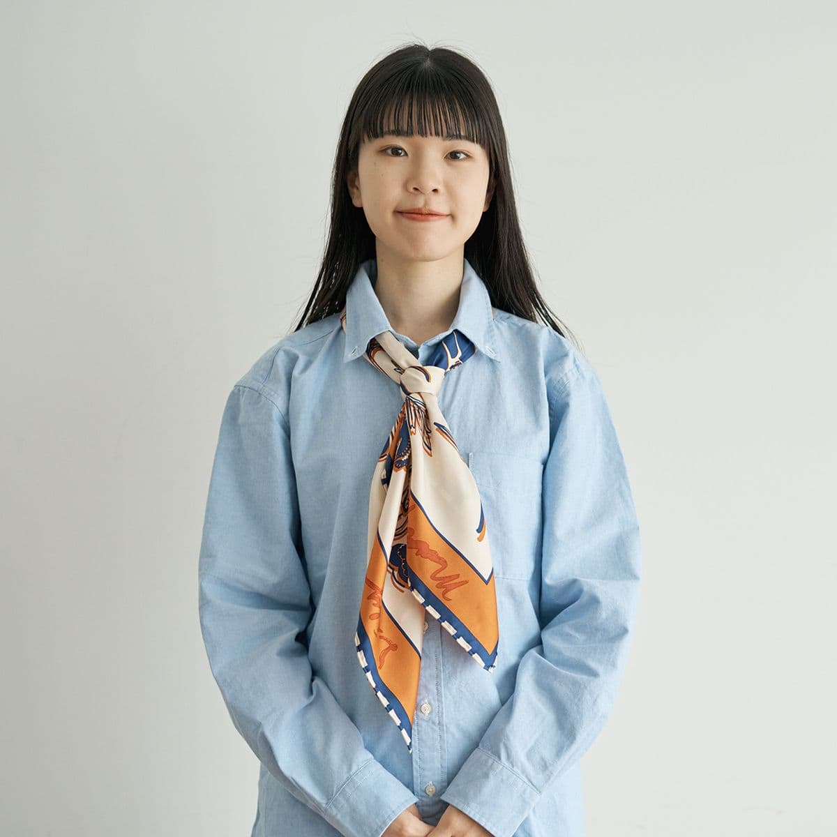 スカーフの形を整えると、ネクタイのようなシンプルノット巻きが完成