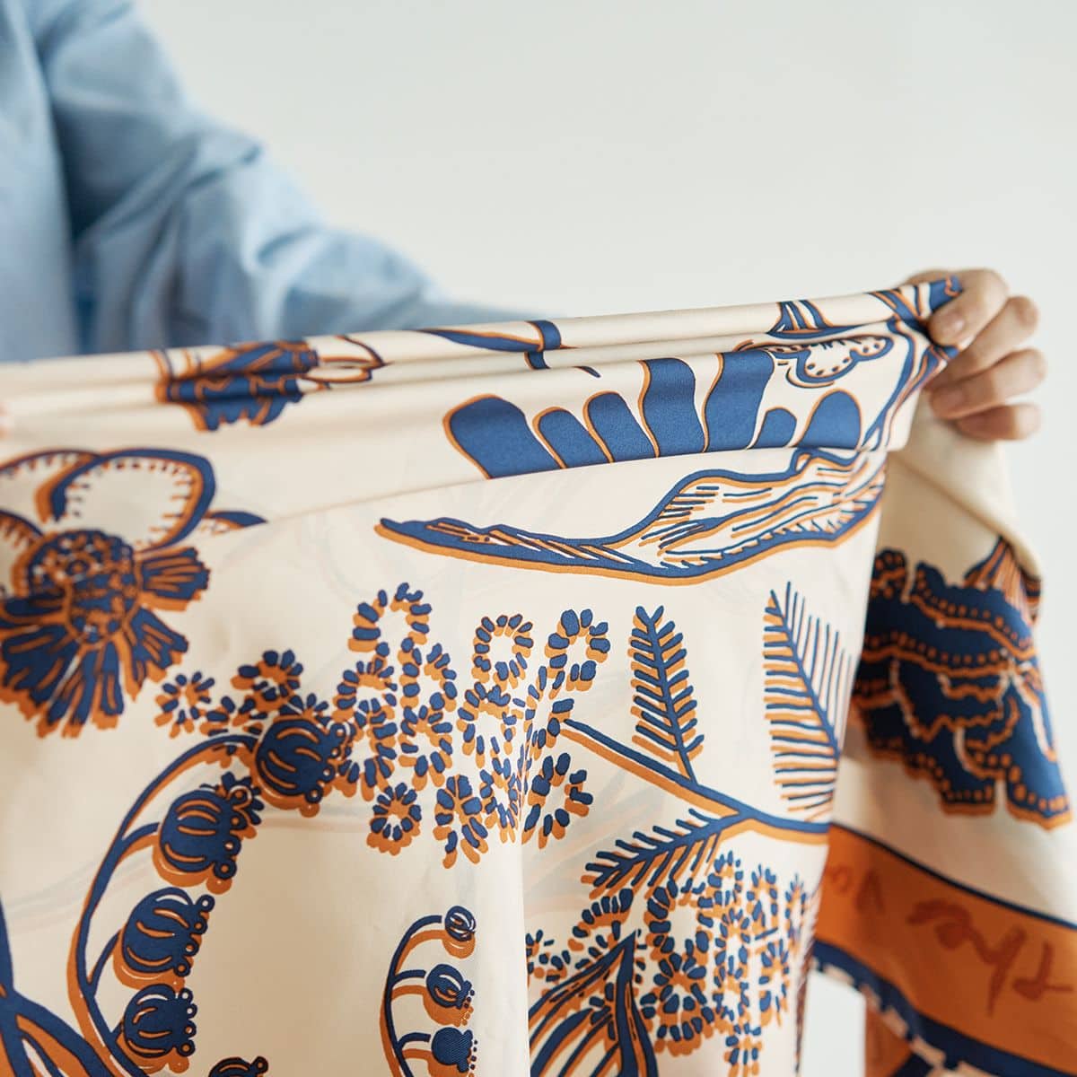 三角形に折ったスカーフの上部を外側へひと折りする