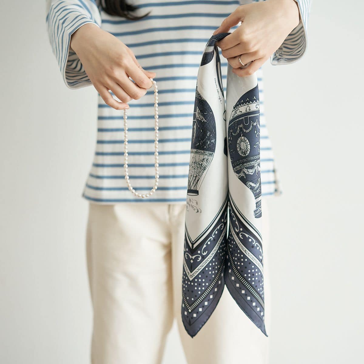 基本のバイアス折りをしたスカーフとパールネックレスを用意します