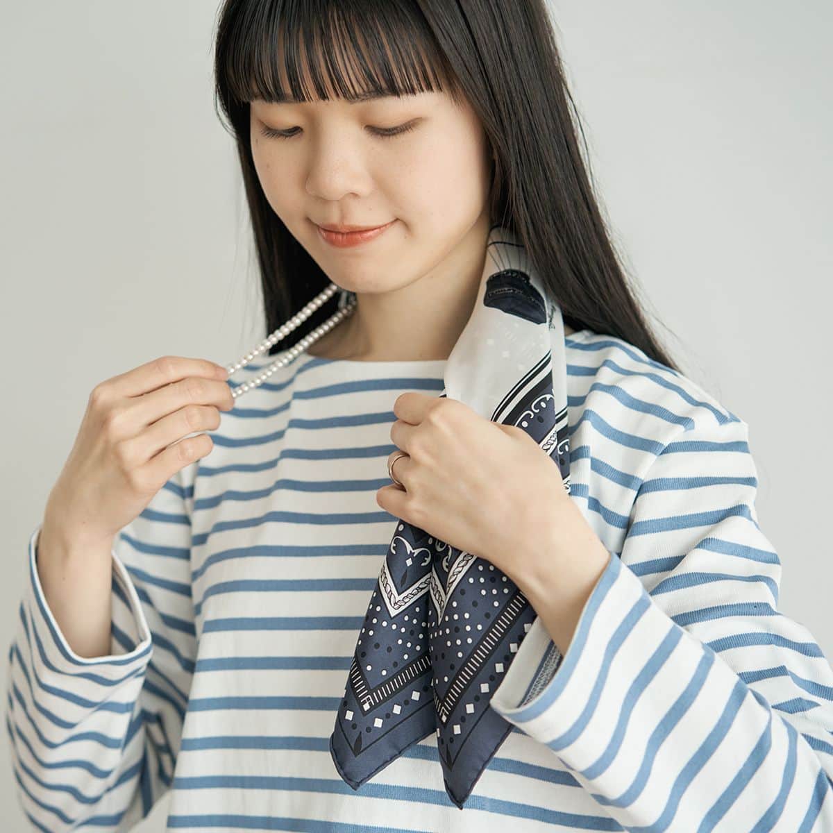 スカーフとネックレスの境目が首の後ろにくるように、首にかけて調節