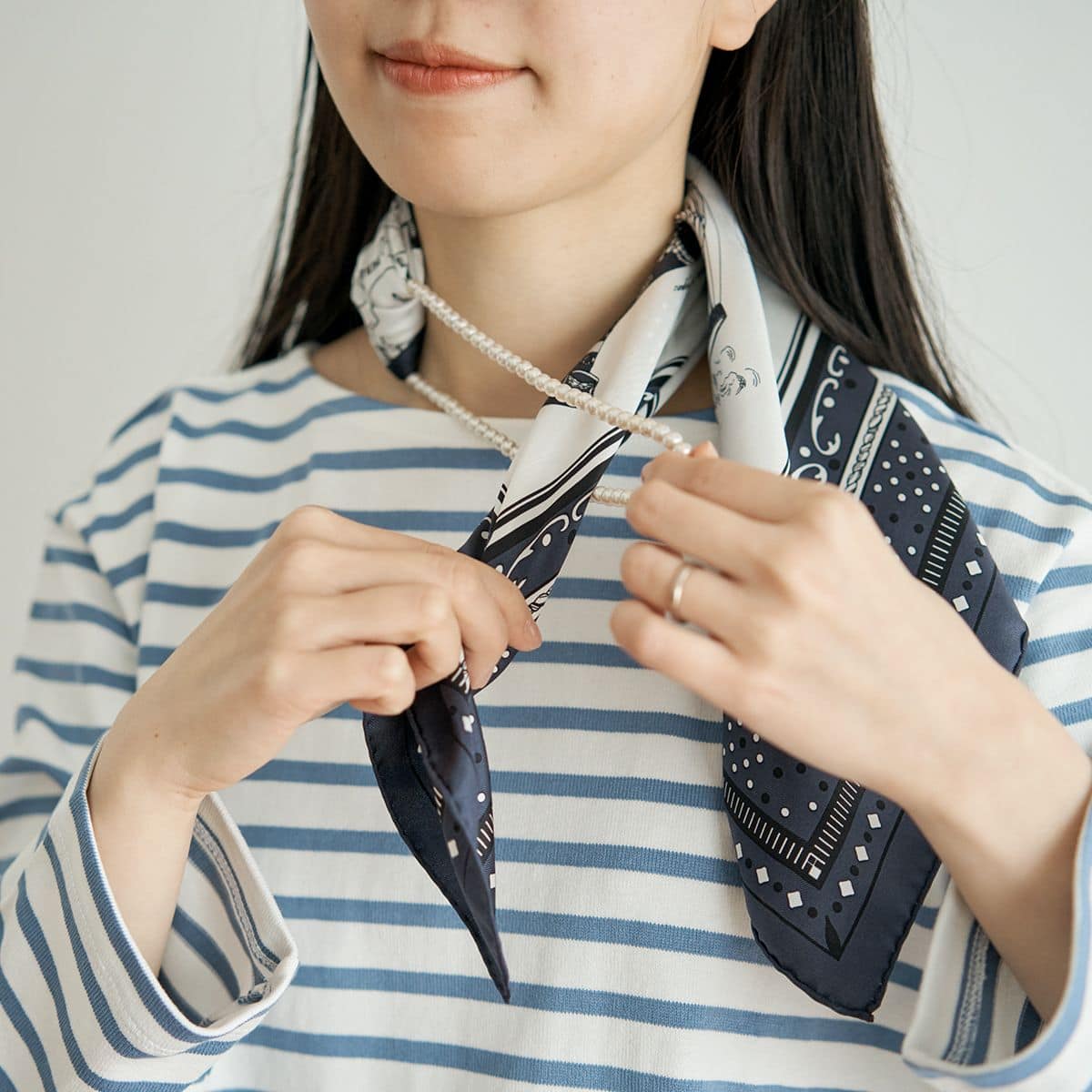 片側に寄せ2本あるスカーフの内側にある一本を、ネックレスの輪っかに通す