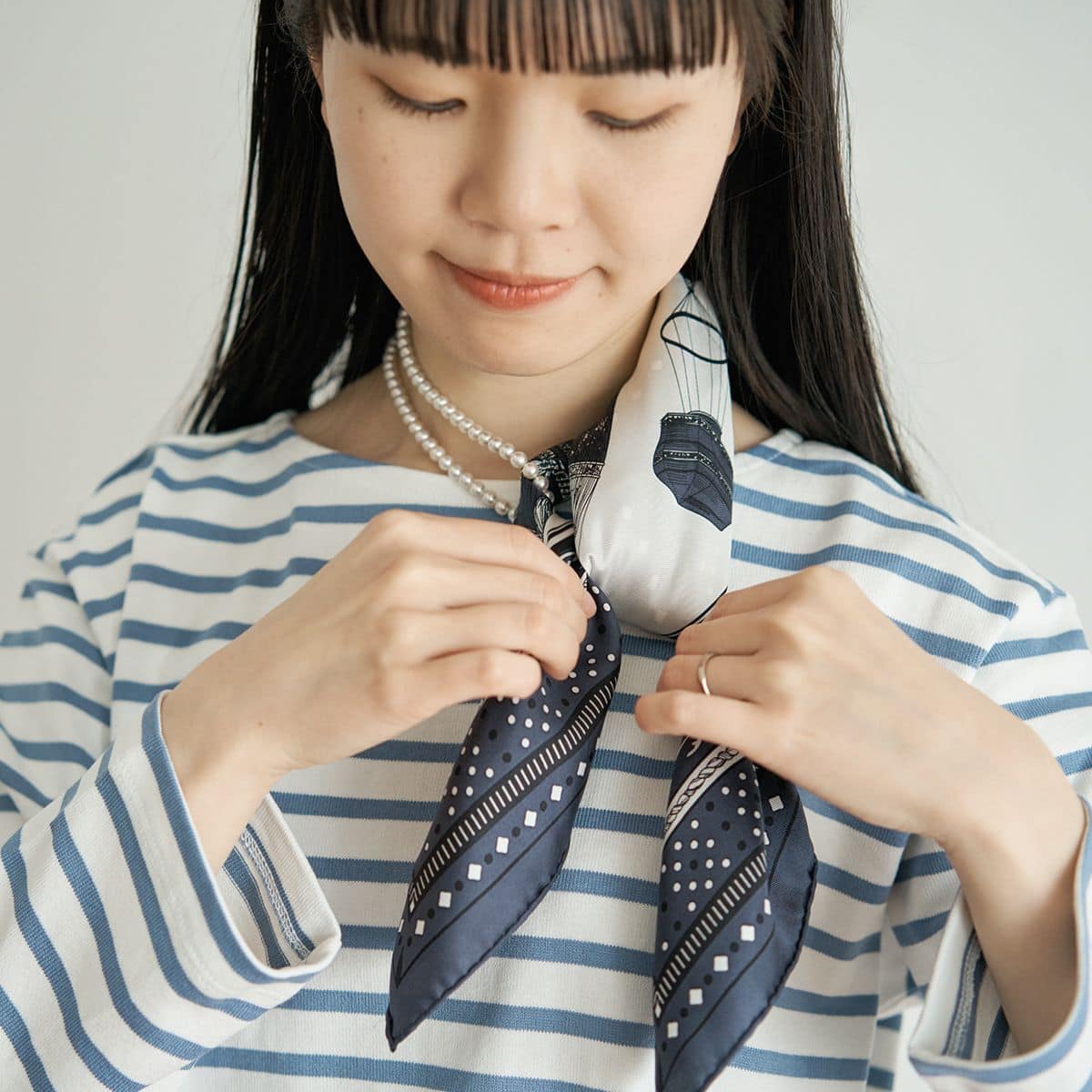 ネックレスに通したスカーフと通していないスカーフを結ぶ