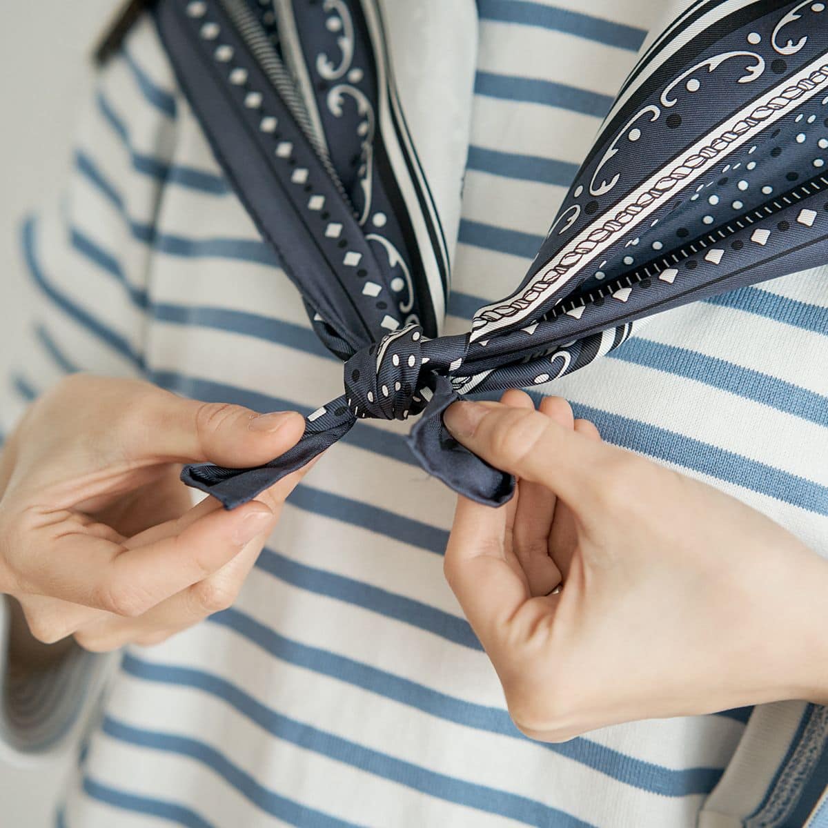 肩に掛けたスカーフを、なるべく端の方で小さく結ぶ