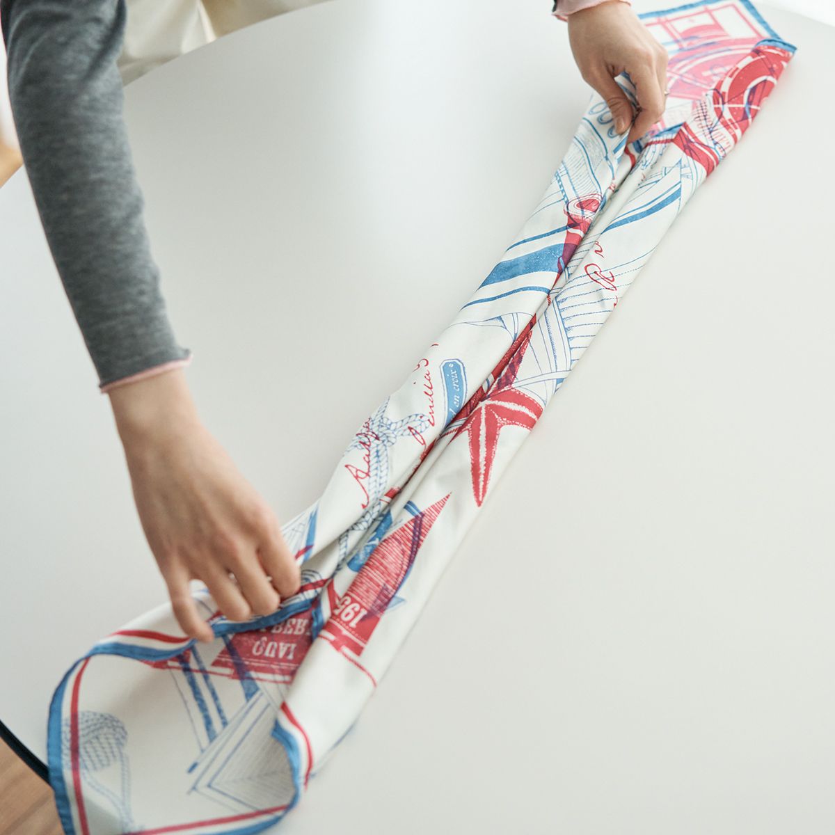 スカーフの端を追った部分を、さらにもう一度折った部分を内側へ折る