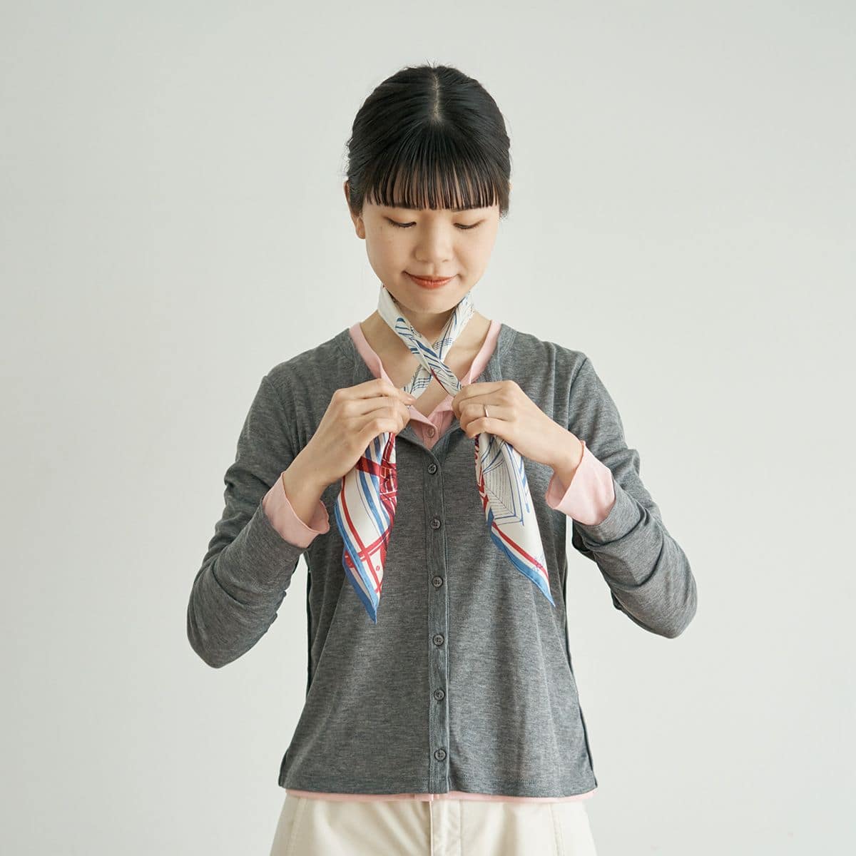 基本のバイアス折りをしたスカーフを、首に掛けて前でクロスする