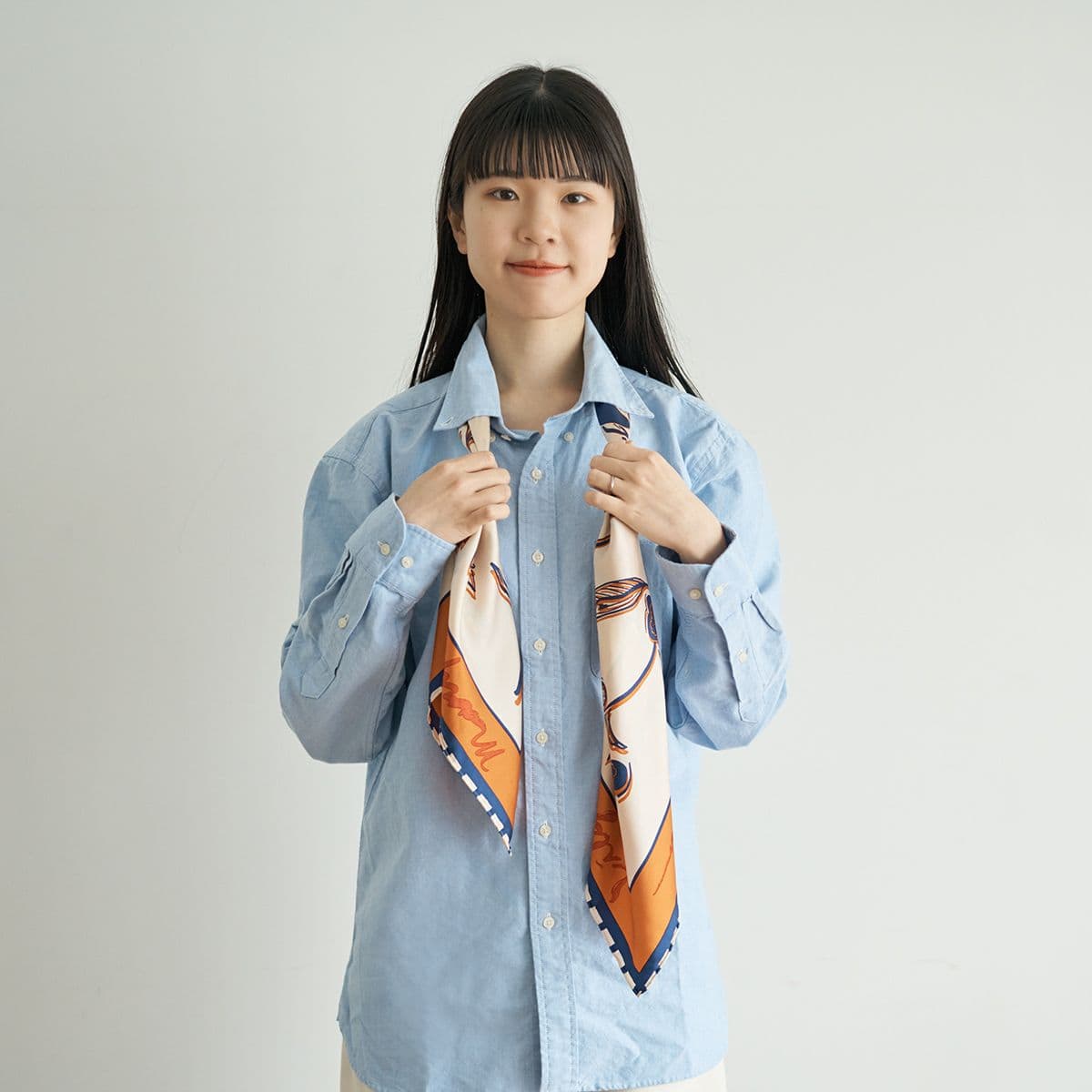 バイアス折りをしたスカーフを、片方を長めにして首にかける