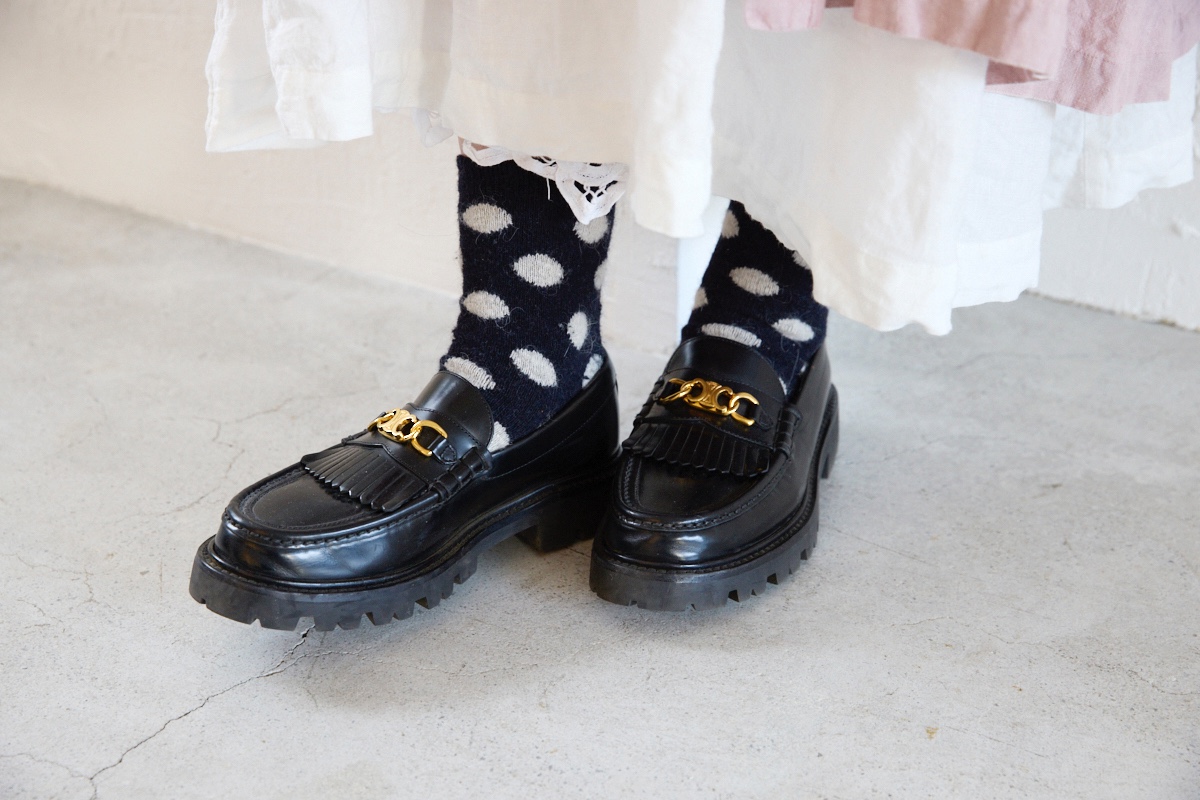 黒のセリーヌのマーガレットローファーとモノトーンのドット柄ソックスを合わせた足もと