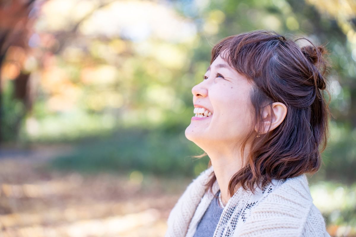 ヘアピンを使ってハーフアップに髪をアレンジした様子。外で空を見上げている。