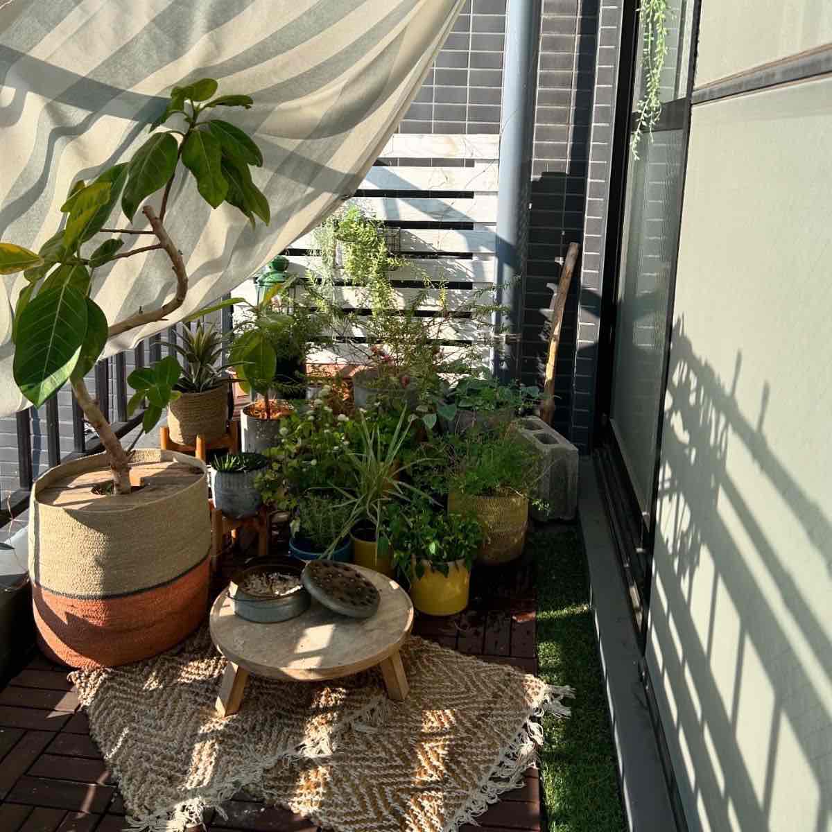 人工芝を敷いて観葉植物を並べた賃貸マンションのベランダ