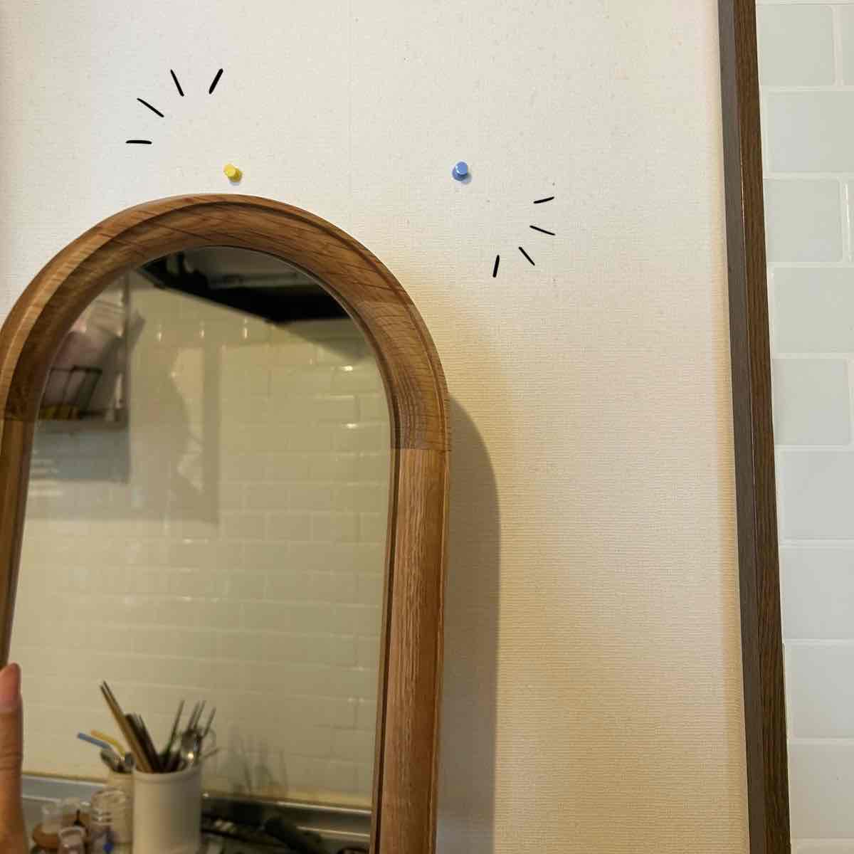 アーチ型ミラーを飾るために画びょうを刺した壁面