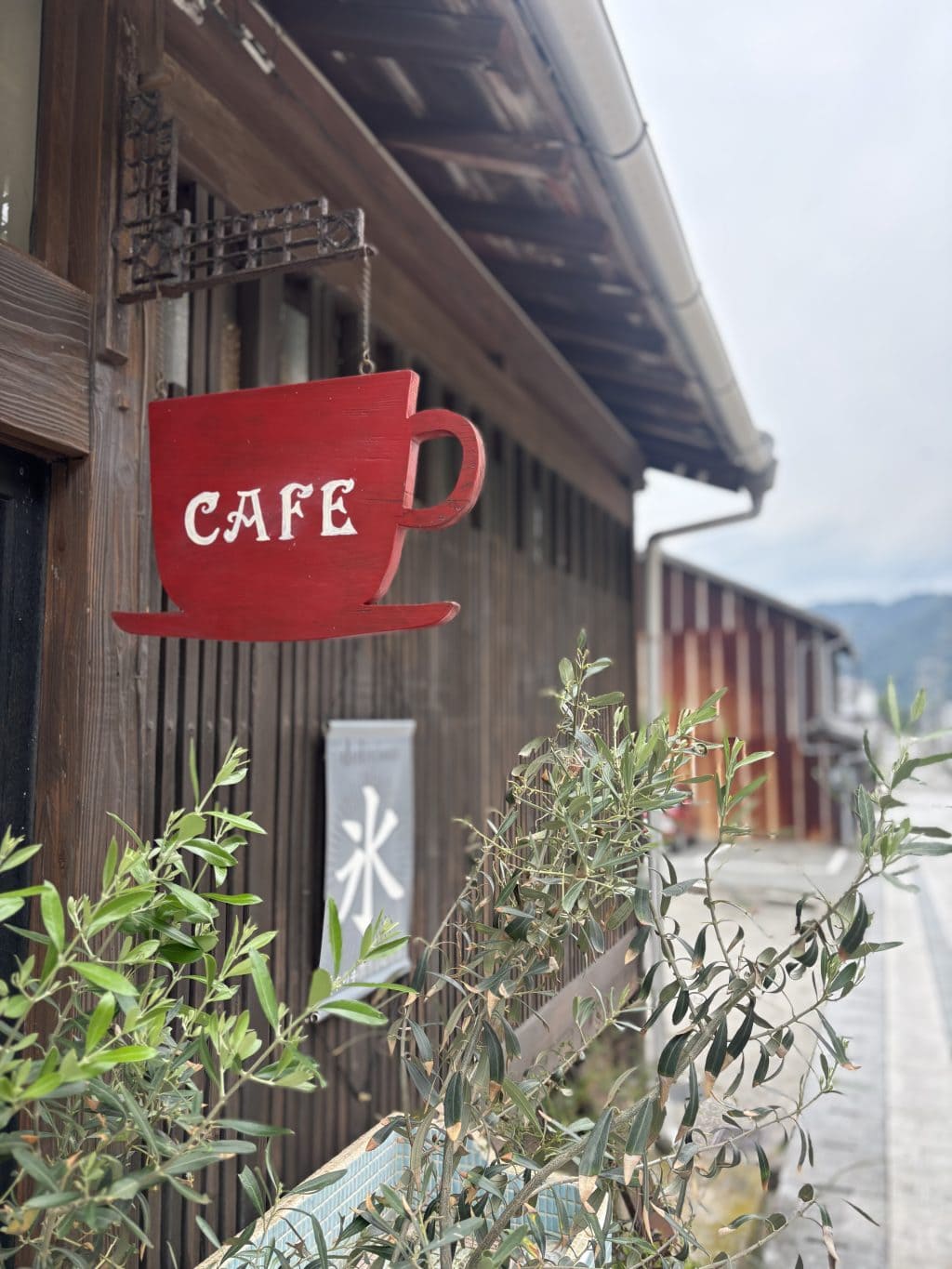 カフェ暖木さんの外観。赤いカップの看板がかわいい。