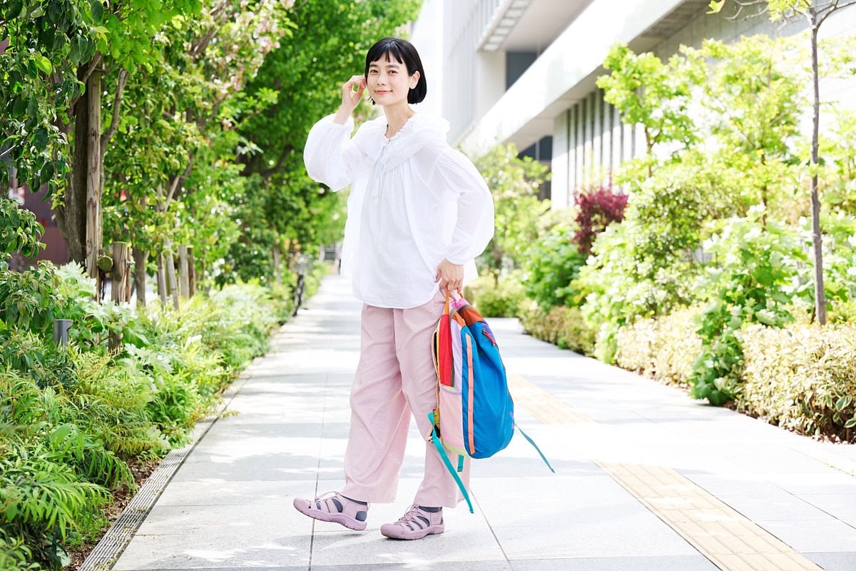 アクティブな印象のバックパックも、やわらかな色合いの装いと合わせれば大人らしい雰囲気に。