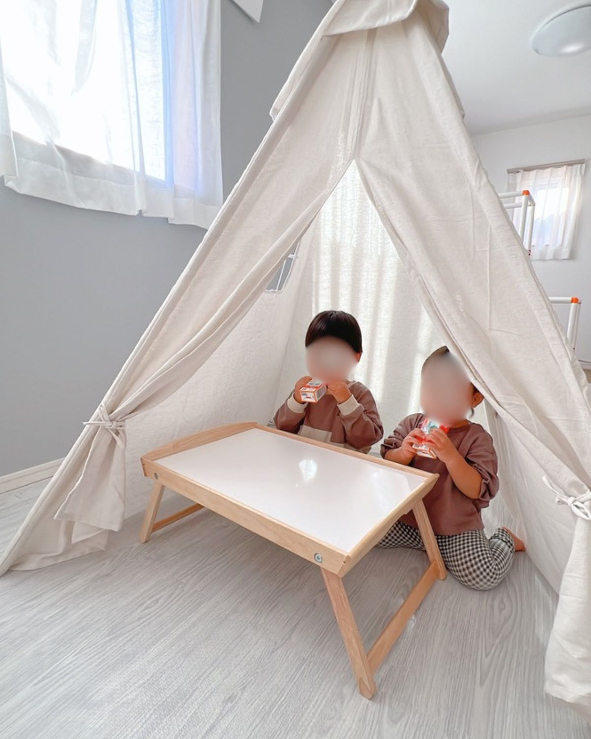 室内用のテントの中でおやつを食べる子どもたち。