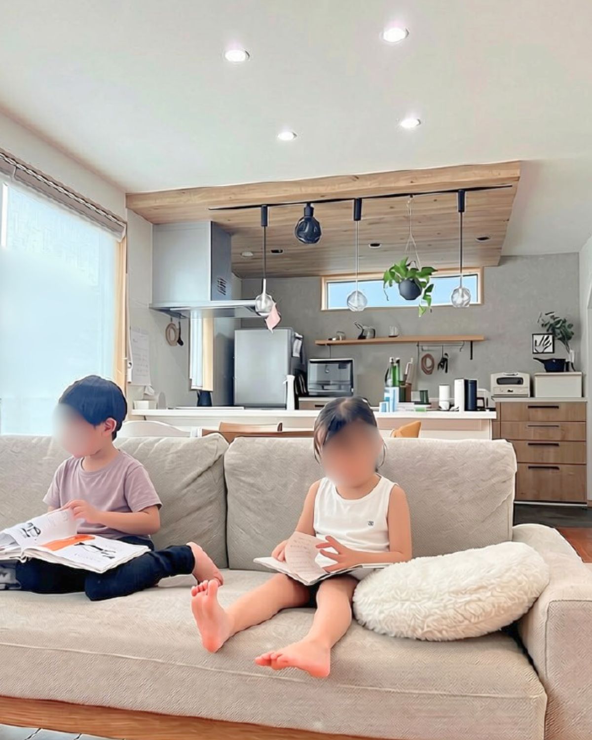 北欧モダンなソファーでくつろぎながら読書をする男の子と女の子