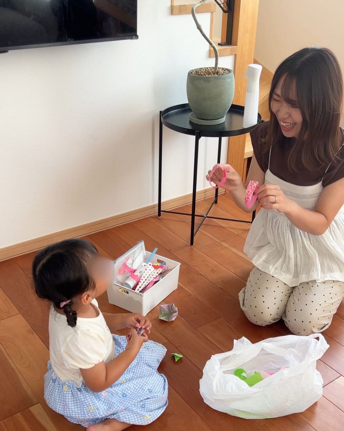 折り紙などで作った作品を整理する親子