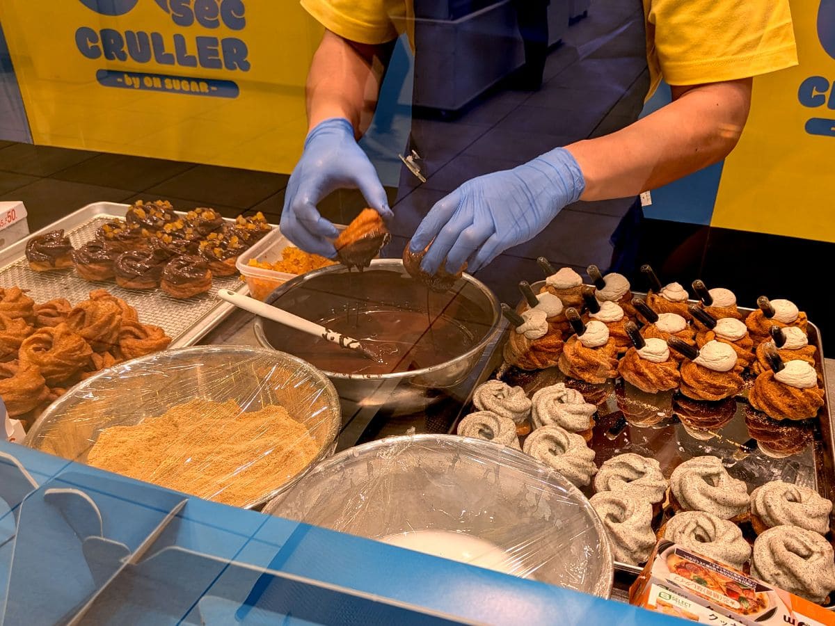 60sec CRULLER by ON SUGARの実演販売ブースでパティシエがフレンチクルーラーを作っているところ