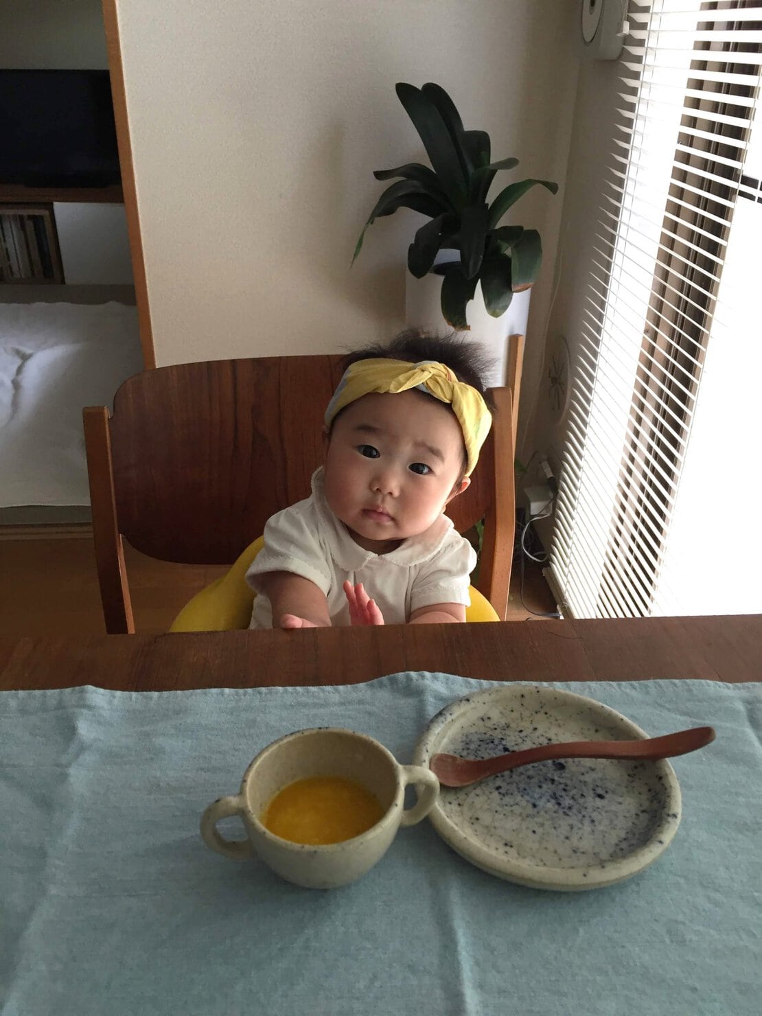 おばが作ってくれたお食い初め用の小さな平皿と持ち手が二つついた陶器で離乳食を食べる娘